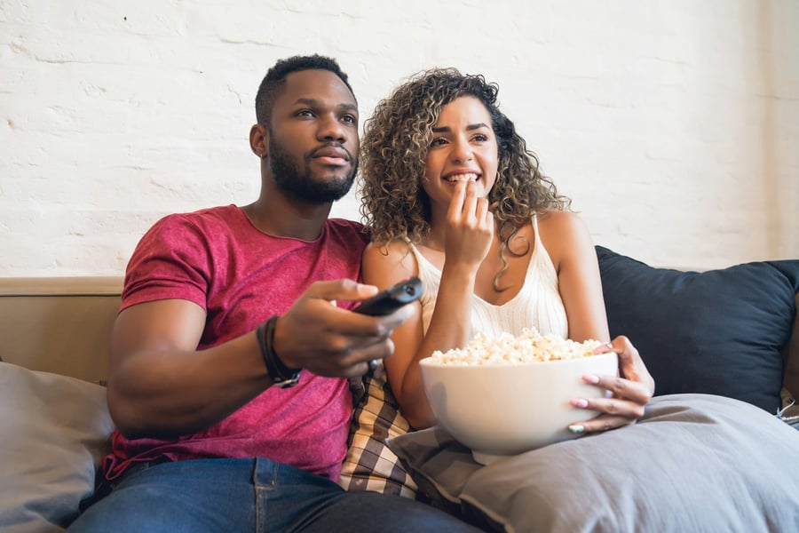 A couple holding the remote while their channel is unavailable