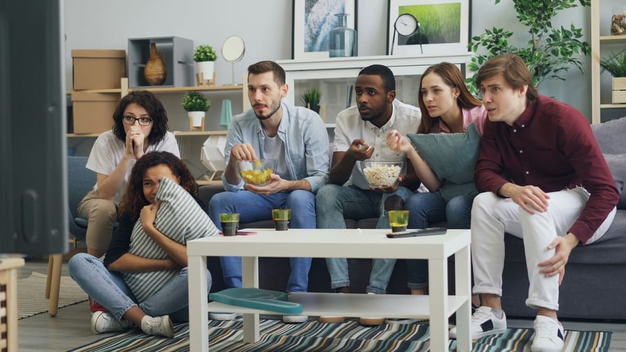 Friends watching a tense moment on TV