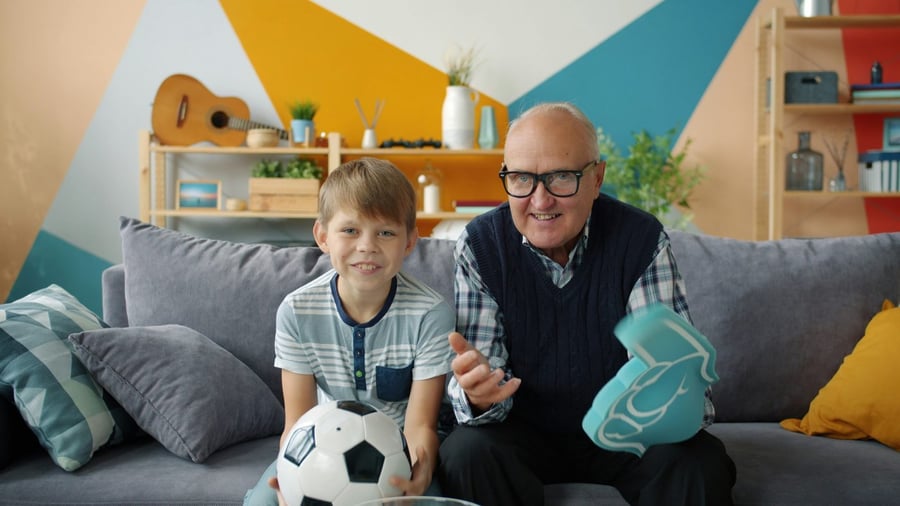 A grandfather and grandson cheering at the game