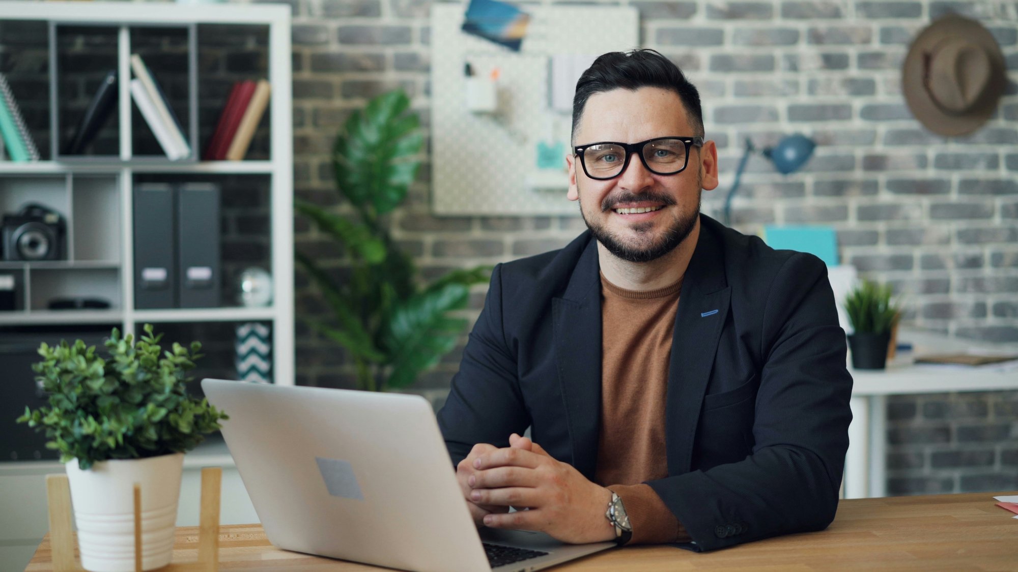 Smiling man at a laptop in a home office