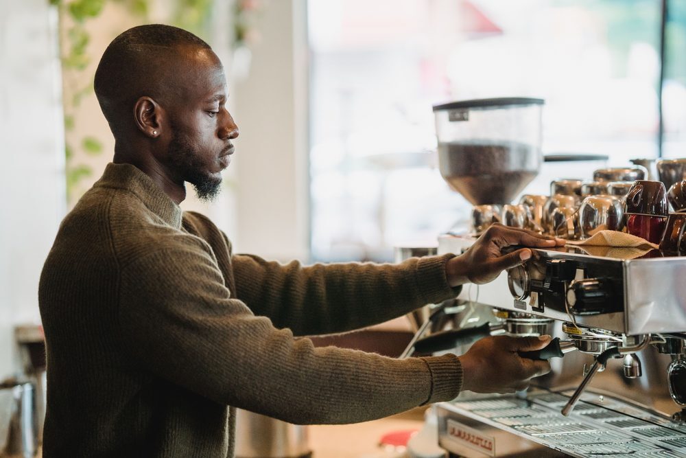 A barista pulls an espresso shot at a commercial espresso machine