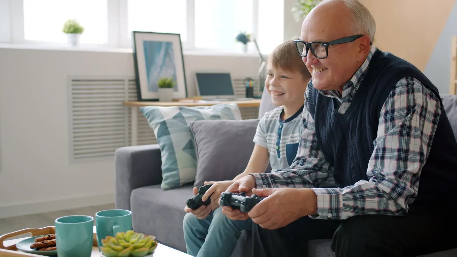 Grandfather and grandson playing video games on the couch